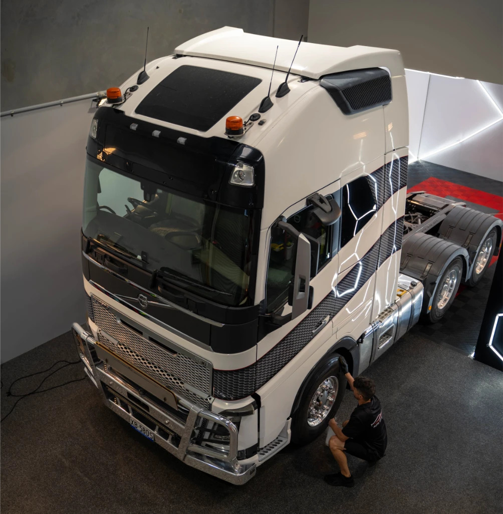 Detailer polishing a white Volvo prime mover truck in the Auto Affection Detailing studio